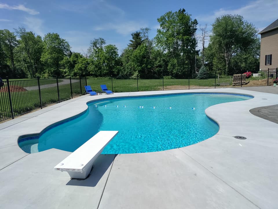 A large swimming pool with a diving board in the middle