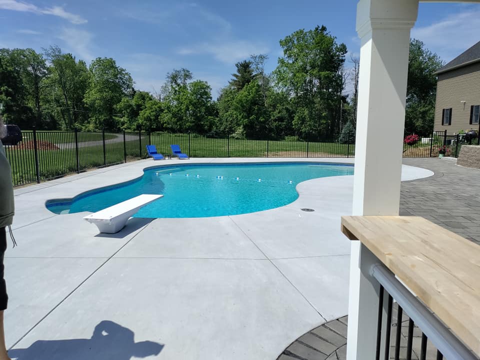 A large swimming pool with a diving board in the middle