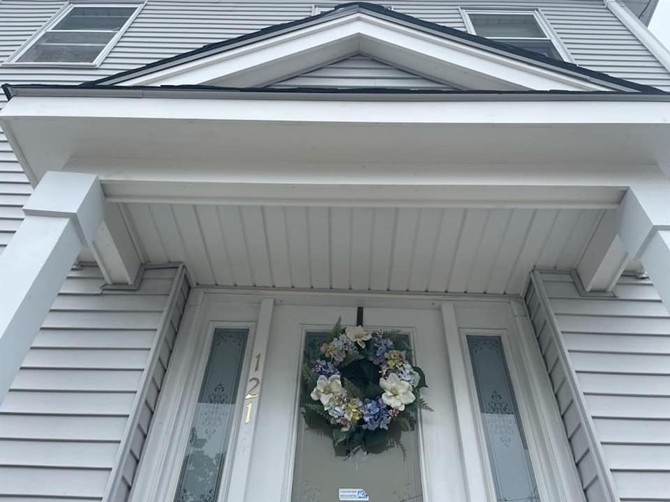 A white house with a wreath on the door