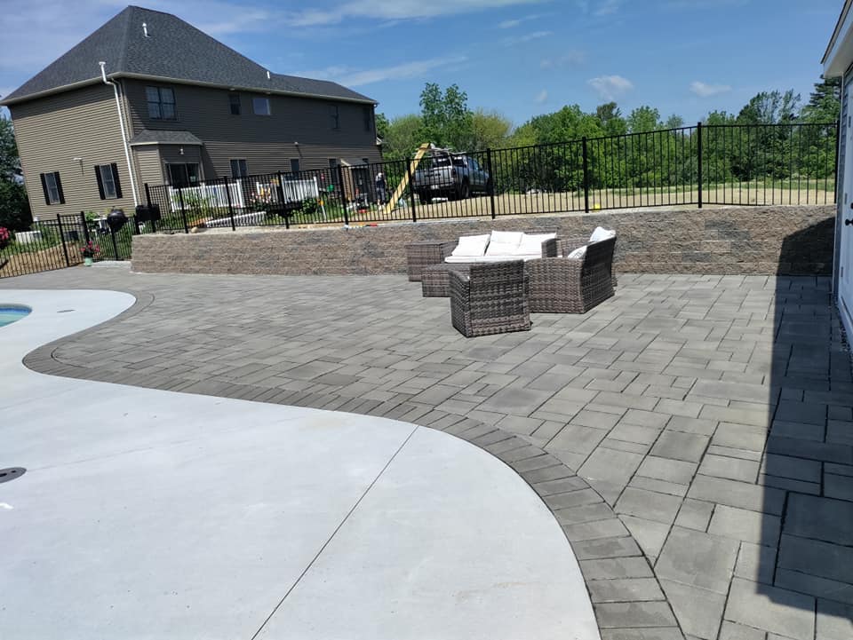 A patio with a couch and a table in front of a house.
