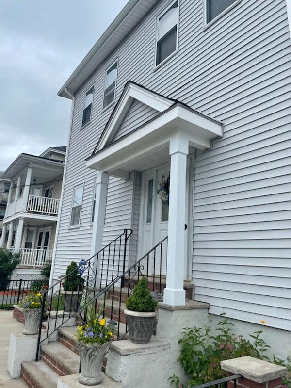 A white house with a porch and stairs