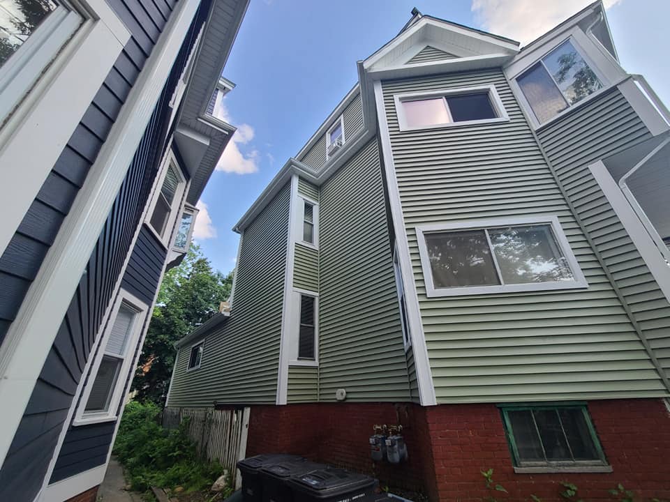 A large house with a lot of windows is surrounded by smaller houses.
