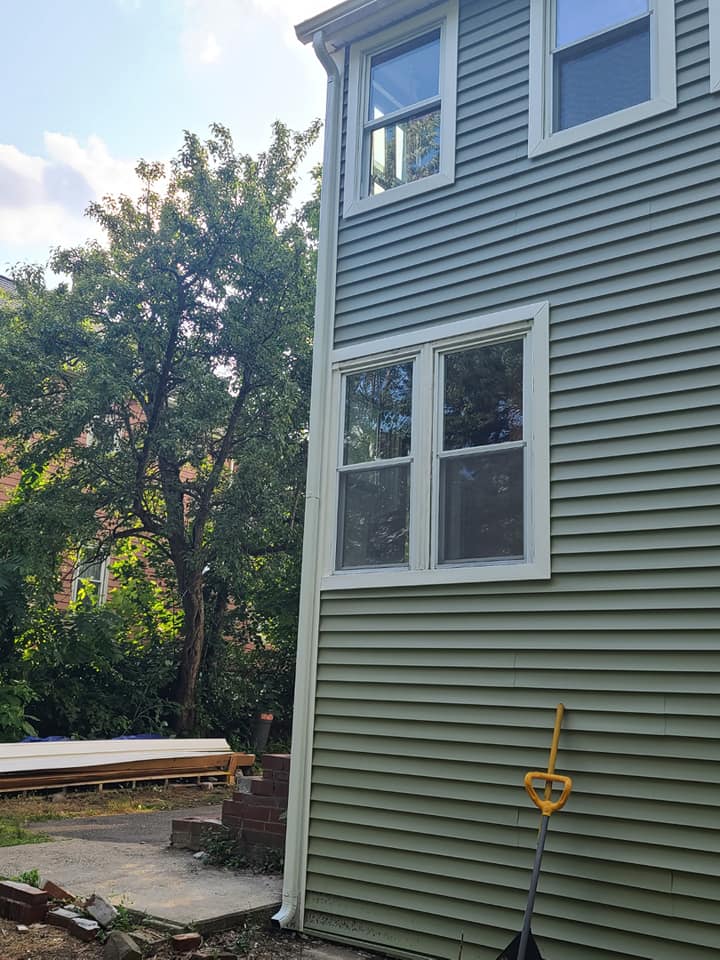 A green house with a shovel on the side of it.