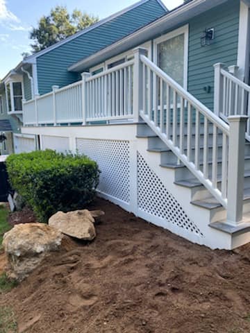 A blue house with white stairs and a white railing.