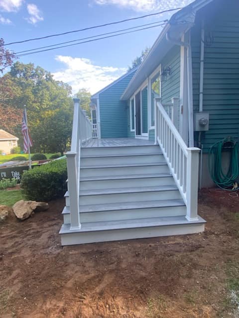 A blue house with white stairs leading up to it.