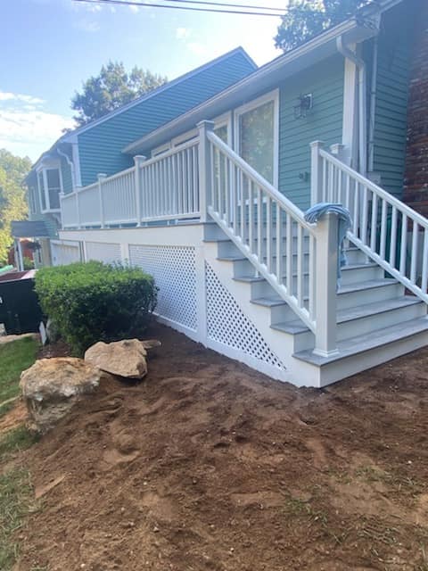 A house with a deck and stairs leading up to it.