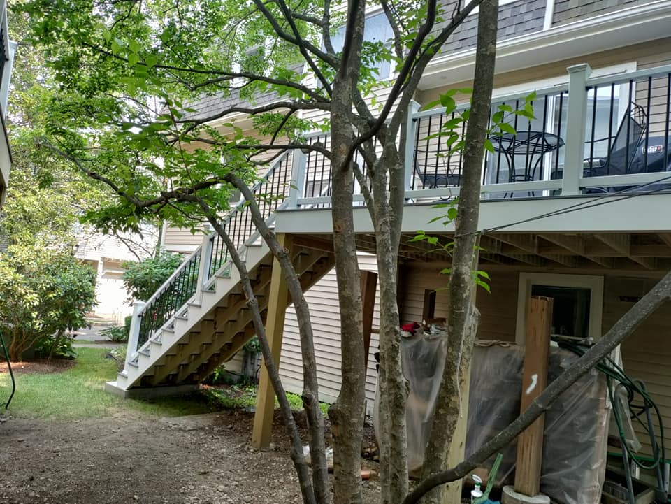 A house with a deck and stairs in the backyard.