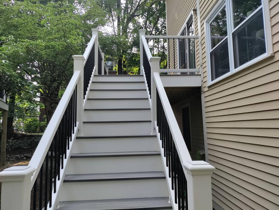 A set of stairs leading up to a deck on the side of a house.
