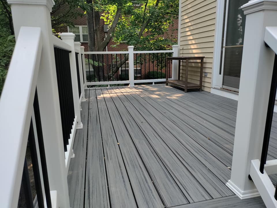 A deck with a white railing and a table on it