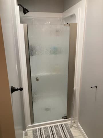 A bathroom with a walk in shower and a bathtub.