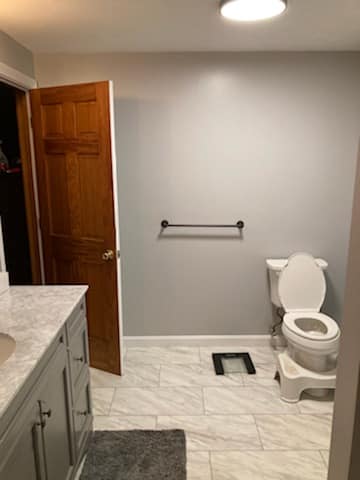 A bathroom with a toilet , sink , and door.