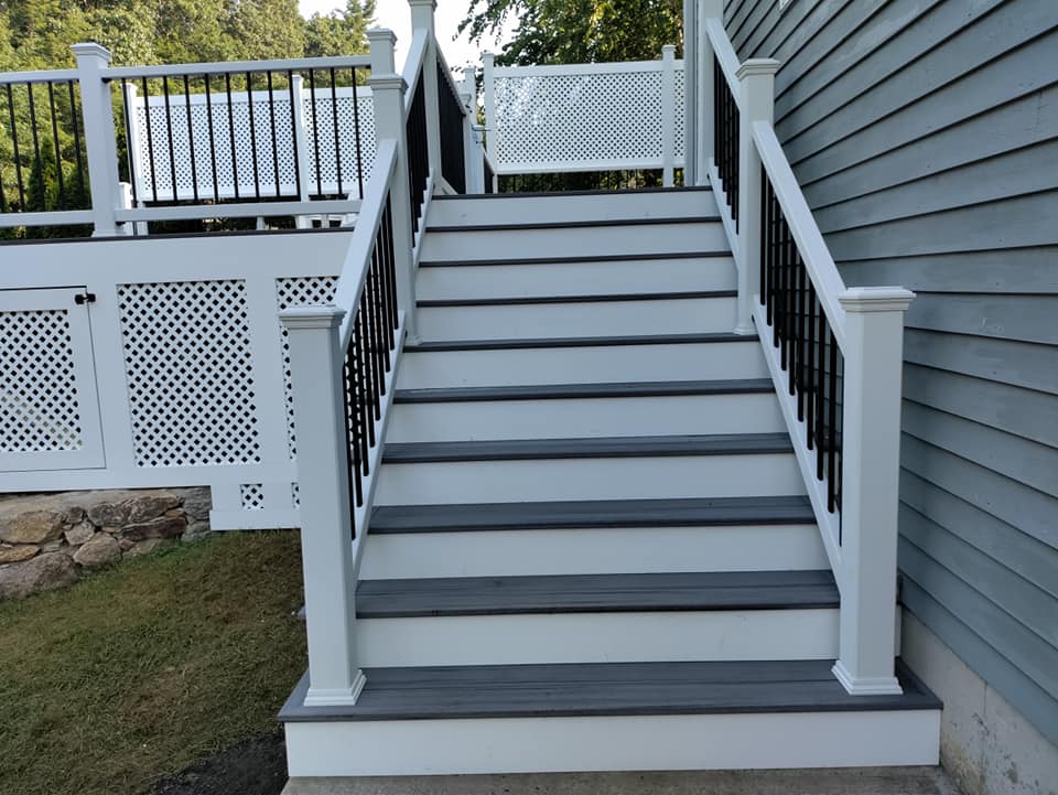 A white deck with stairs leading up to it