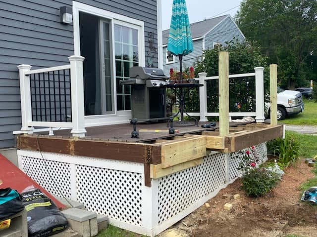 A wooden deck is being built on the side of a house.