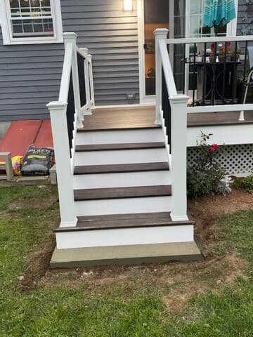 A set of stairs leading up to a deck in front of a house.