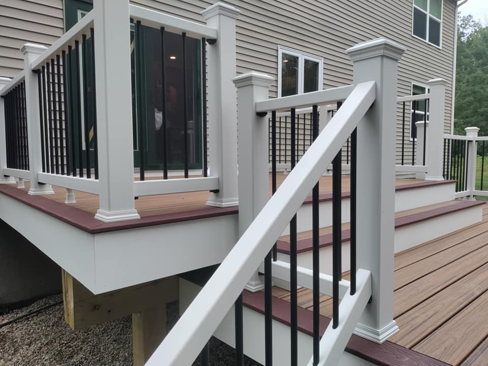 A white deck with black railing and stairs