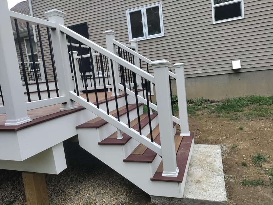 A white deck with stairs and a black railing