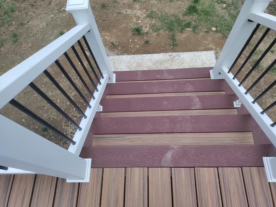 A wooden deck with stairs and a white railing