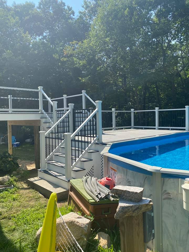 A swimming pool with a deck and stairs next to it