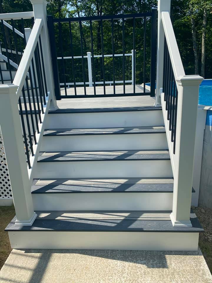 A set of stairs leading up to a pool with a black railing.