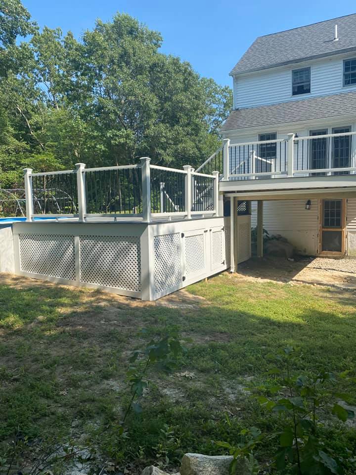 A large white house with a large deck in the backyard.