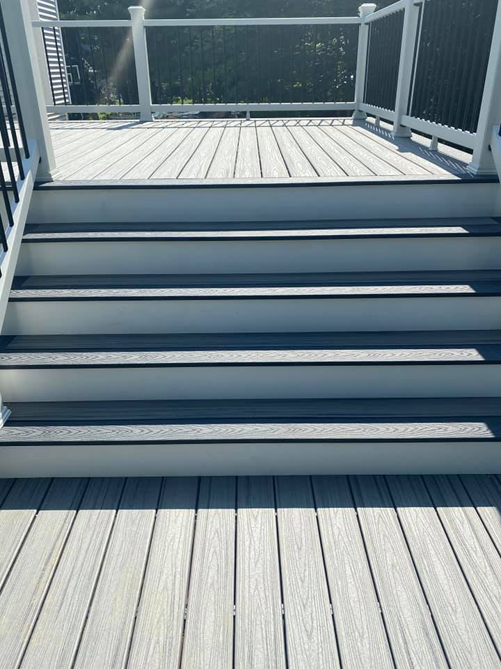 A set of stairs leading up to a deck with a railing.