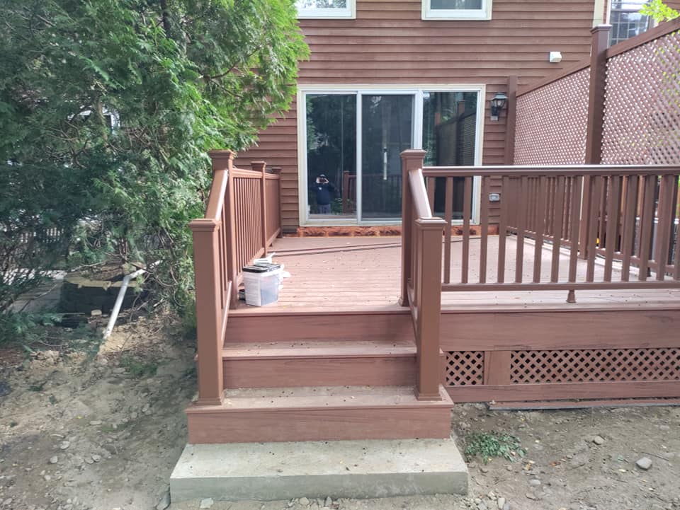 A wooden deck with stairs leading up to a house
