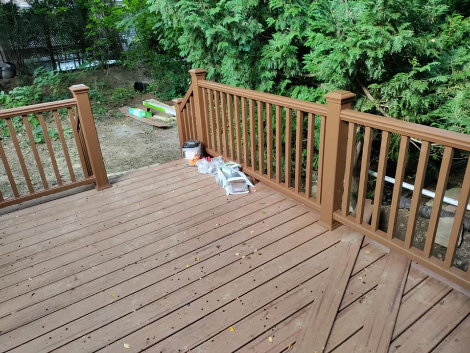 A wooden deck with a railing and a ladder on it
