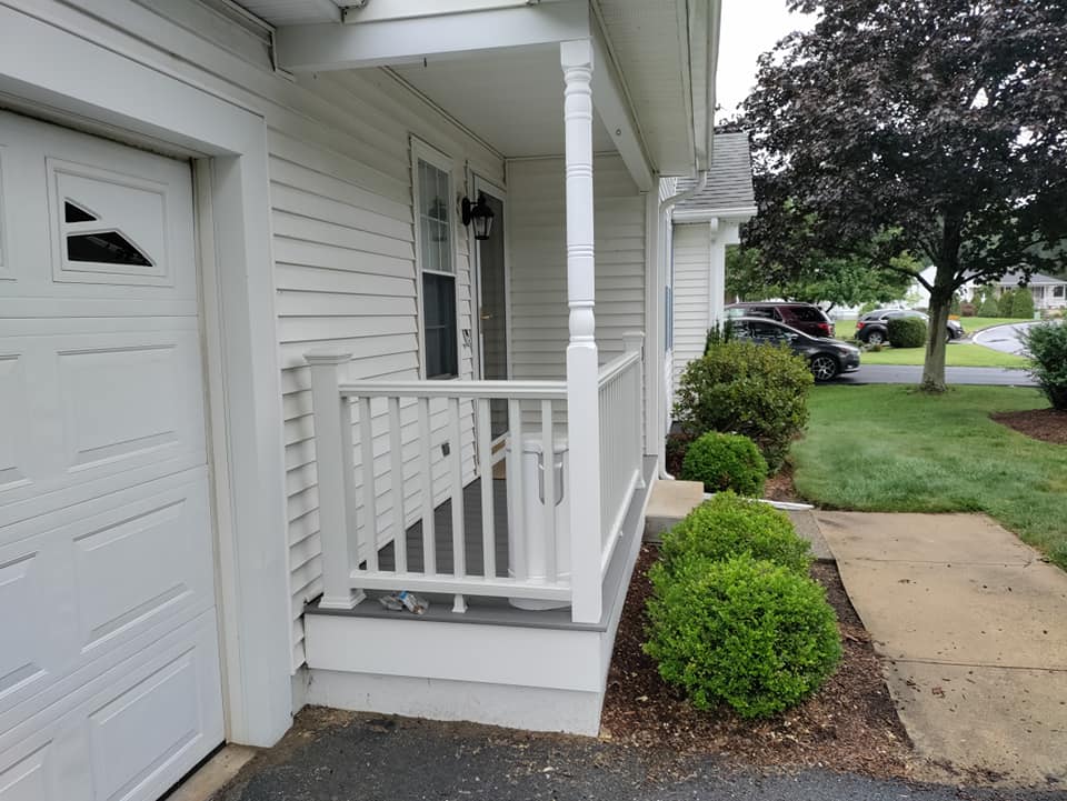 A white house with a porch and a garage door