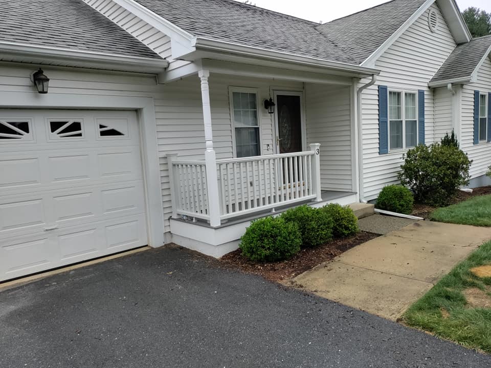 A white house with a porch and a garage door