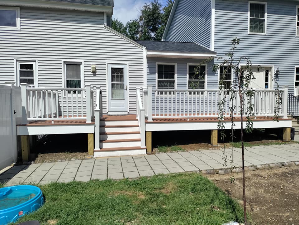 A house with a deck and stairs in front of it