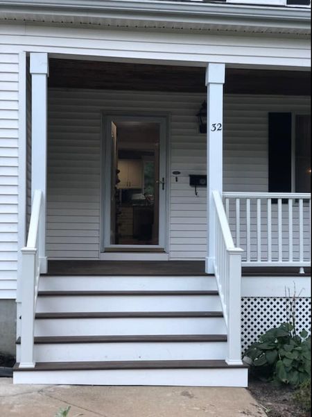 A white house with a porch and stairs