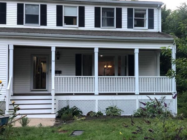 A white house with a porch and black shutters