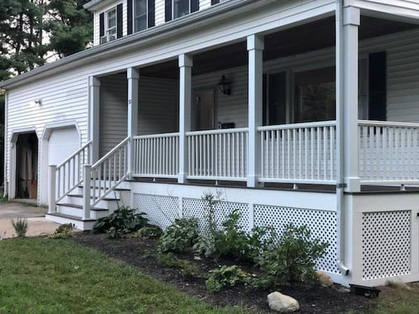 A white house with a large porch and stairs