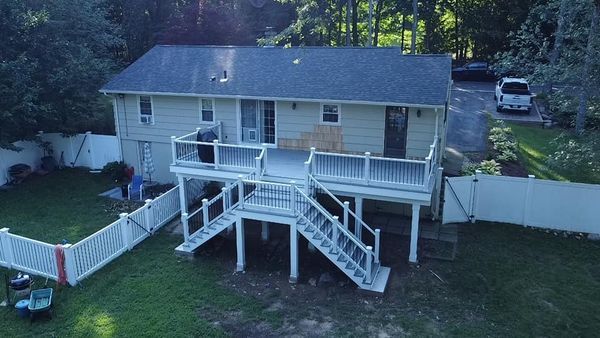 An aerial view of a house with a large deck and stairs.