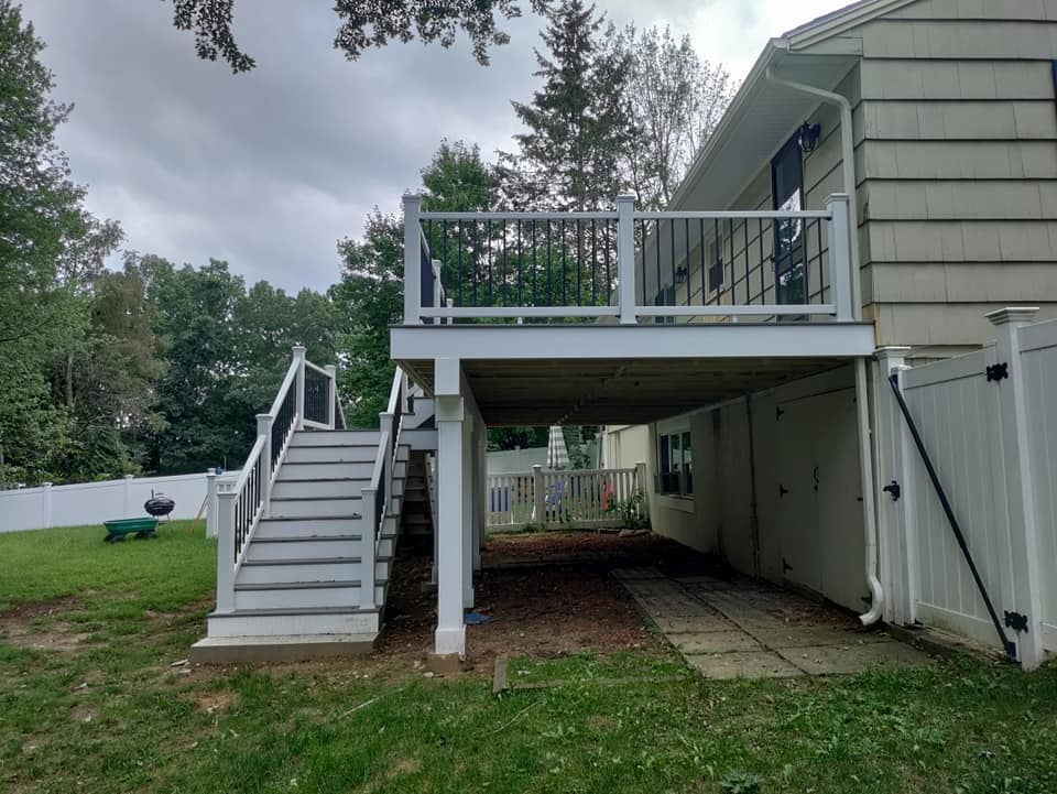 A house with a deck and stairs underneath it.