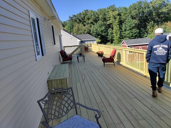 A man wearing a shirt that says ' united states navy ' is walking on a deck