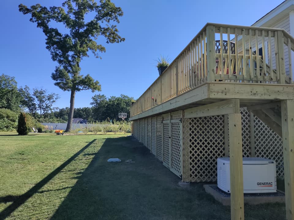 A large wooden deck with a generator underneath it