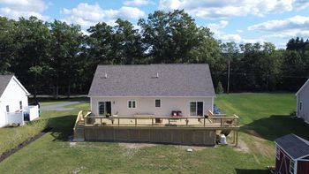 An aerial view of a house with a large deck in the backyard.