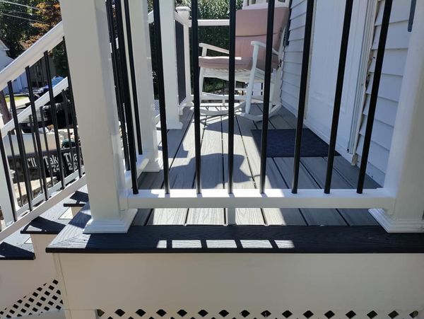 A balcony with a white railing and black bars