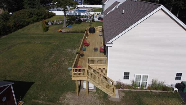 An aerial view of a house with a wooden deck and stairs.