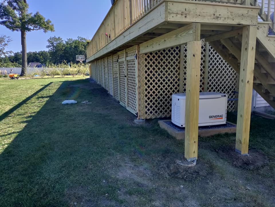 A wooden deck with stairs and a generator underneath it