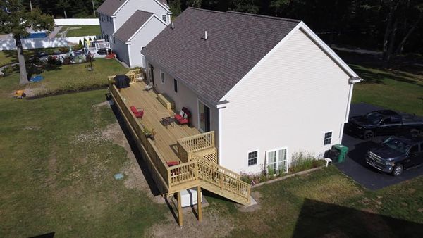 An aerial view of a white house with a wooden deck.