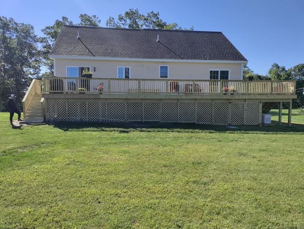 A large house with a large deck in the backyard.