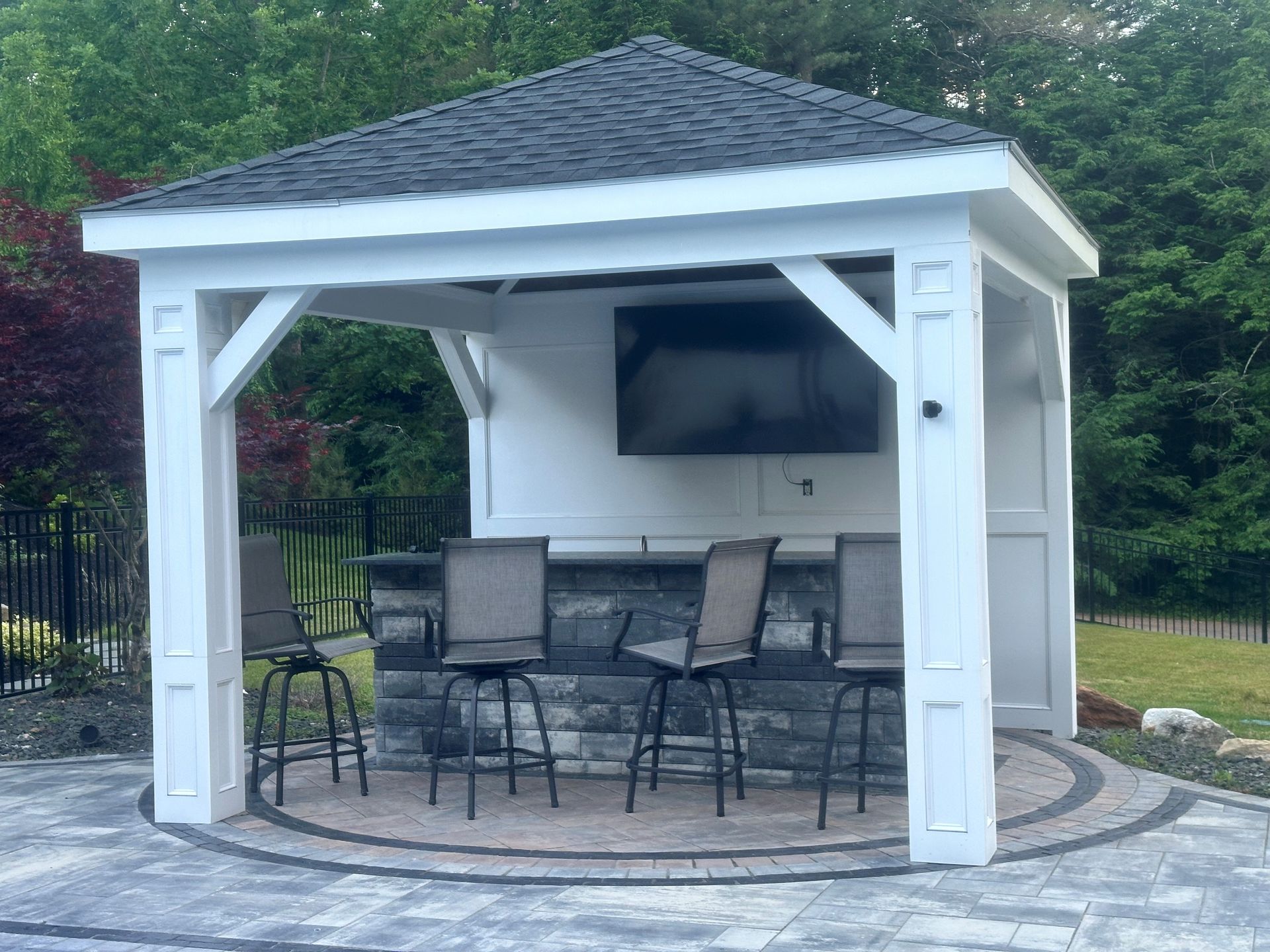A gazebo with chairs and a television on the roof
