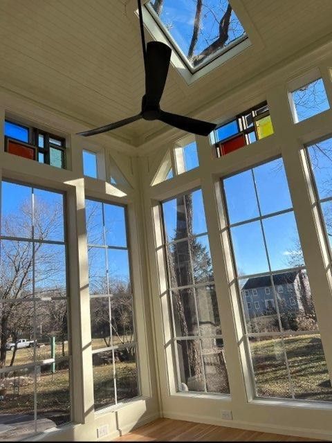 A room with lots of windows and a ceiling fan