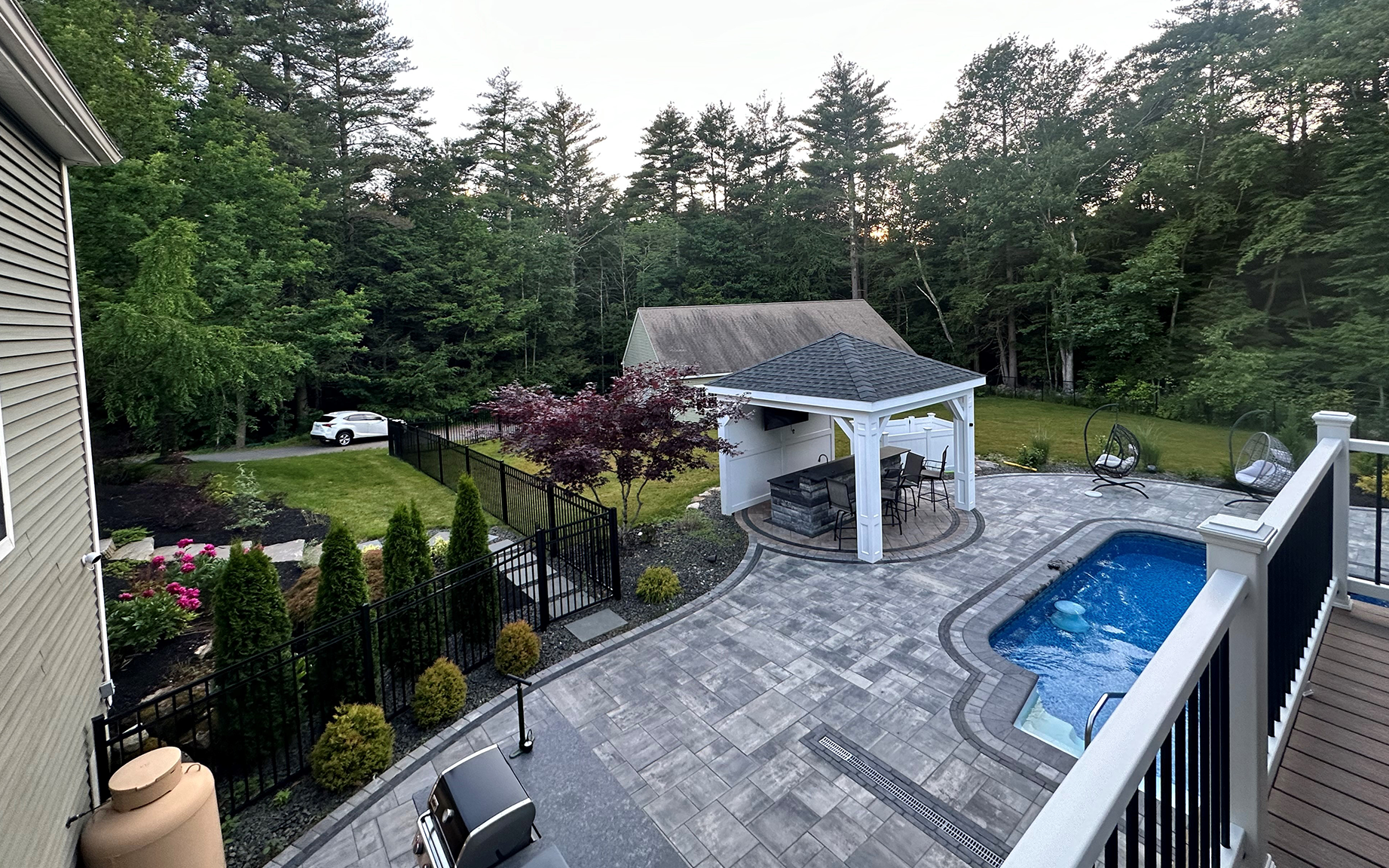 There is a large pool in the backyard of a house.