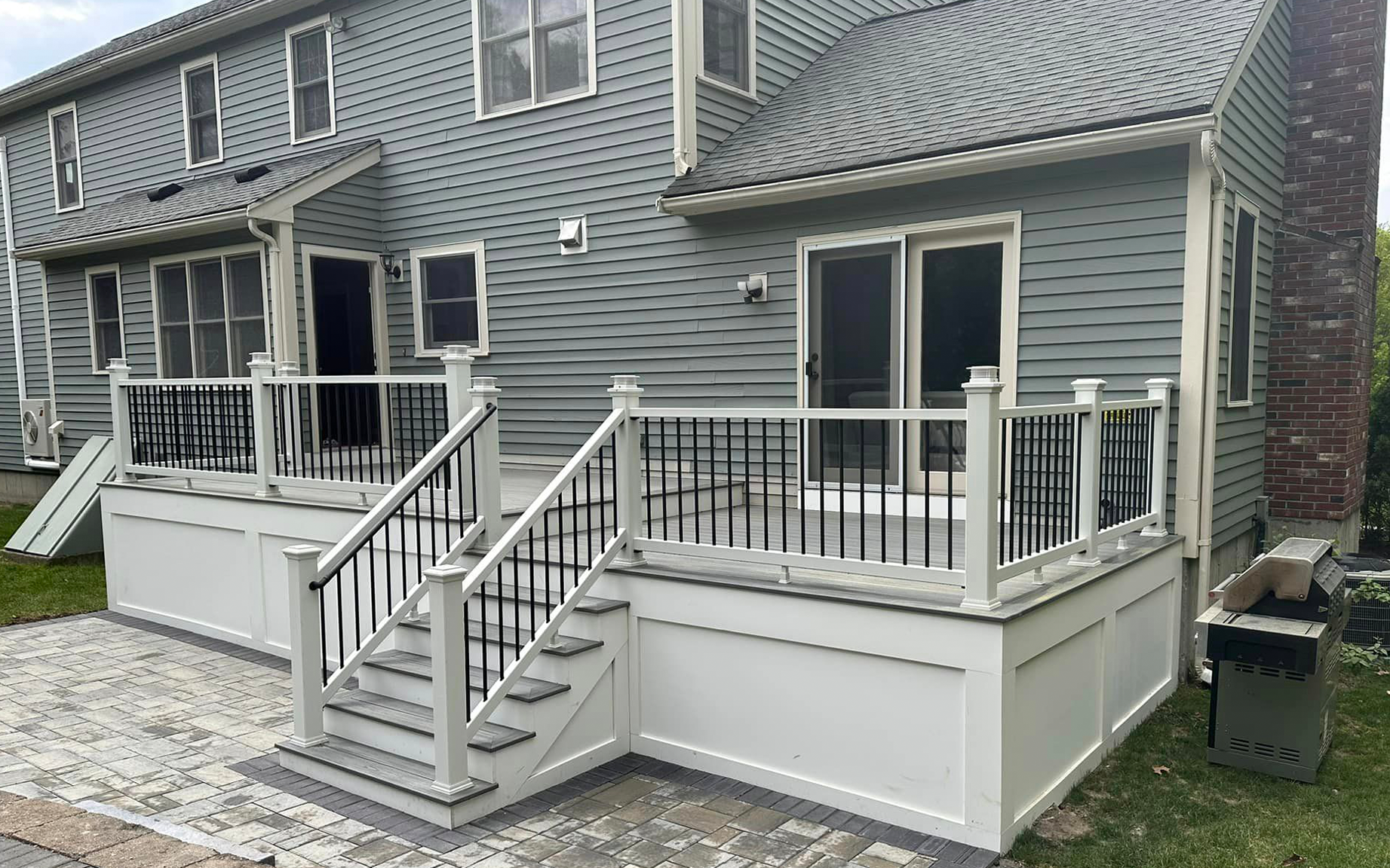 The back of a house with a large deck and stairs.