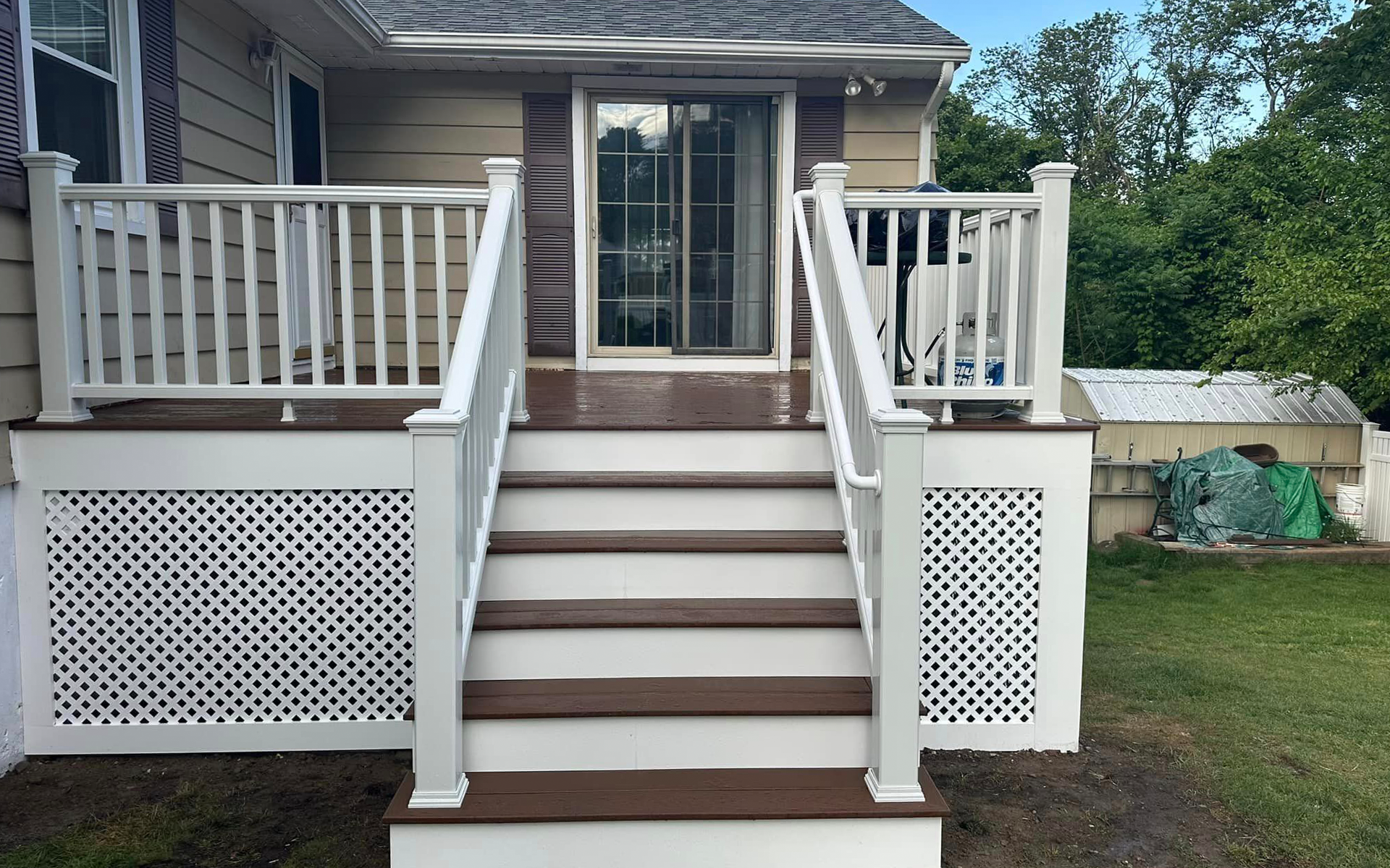 An aerial view of a deck with a table and chairs in front of a house.