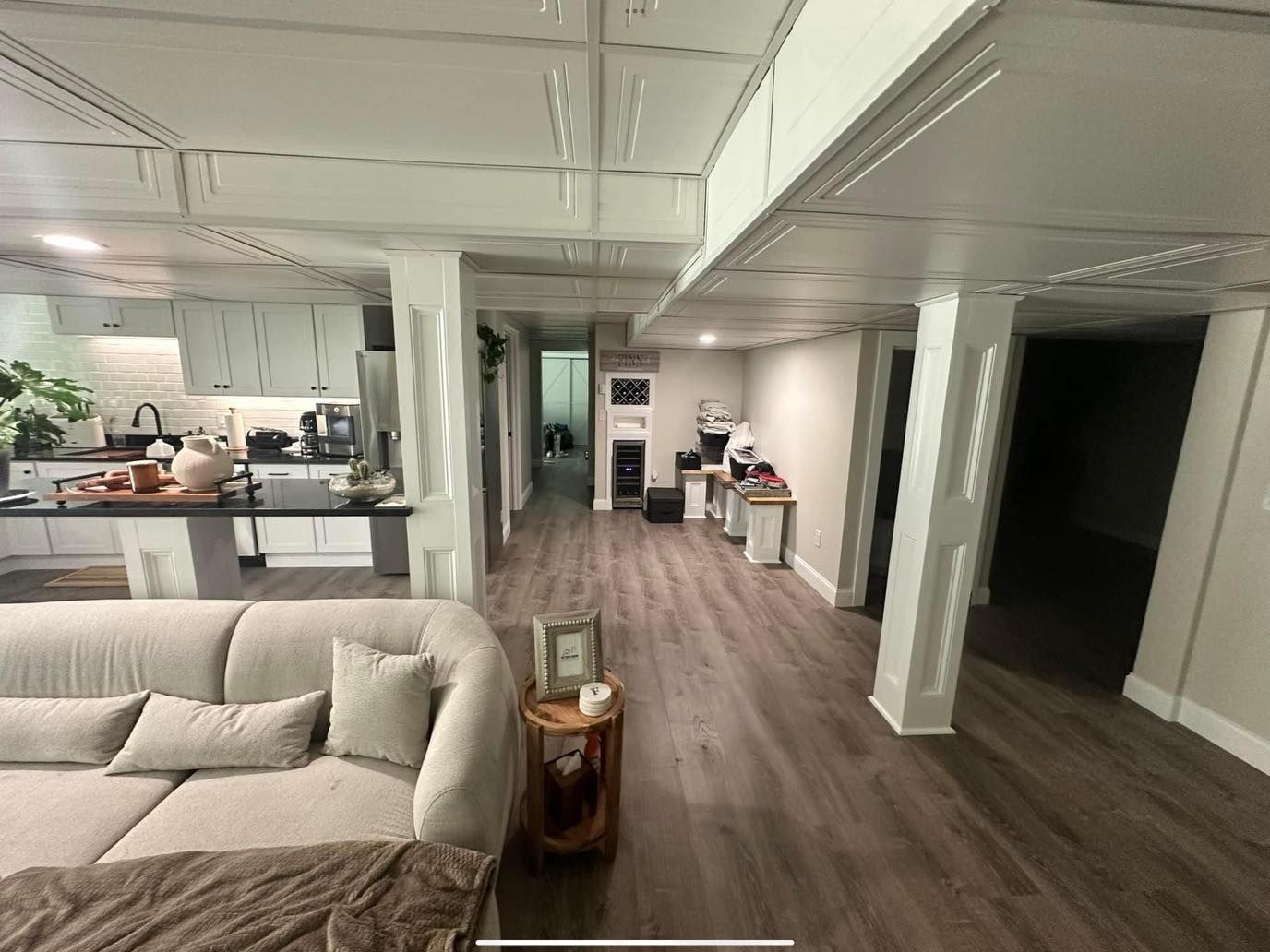 A living room with a couch and a kitchen in the background