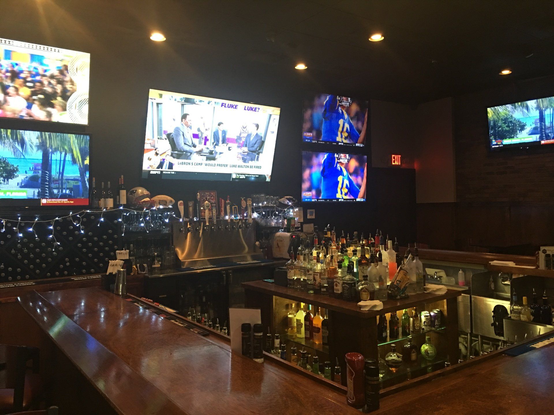 A bar with a lot of televisions on the wall